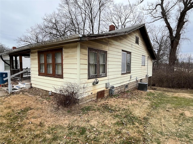 view of property exterior featuring central AC unit and a lawn