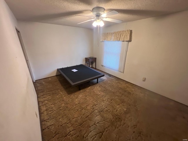 recreation room featuring a textured ceiling and a ceiling fan