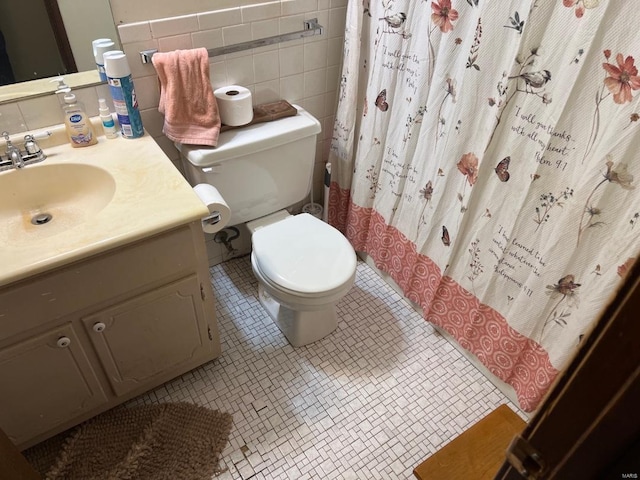 bathroom with toilet, a shower with shower curtain, vanity, tile walls, and tile patterned floors