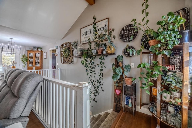 hall featuring lofted ceiling, dark hardwood / wood-style floors, and an inviting chandelier