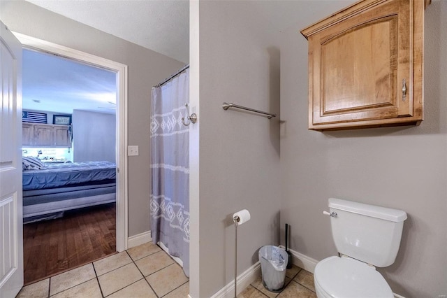 bathroom with walk in shower, tile patterned floors, and toilet