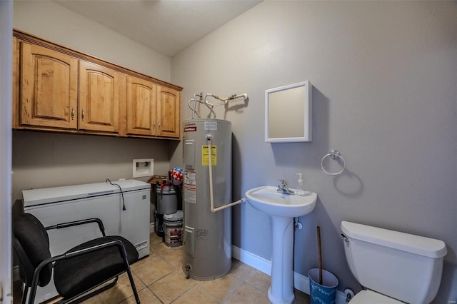 washroom with electric water heater and light tile patterned floors