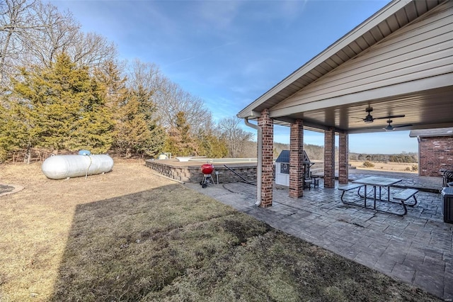 view of yard with ceiling fan and a patio