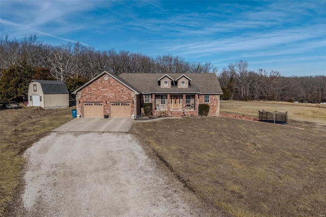 view of front of property with a garage, a shed, a trampoline, and a front yard