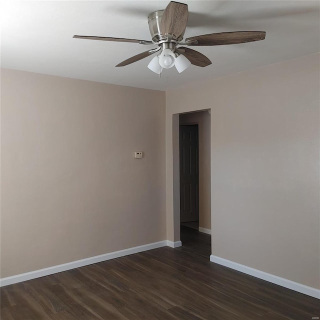 spare room featuring dark wood-type flooring and ceiling fan