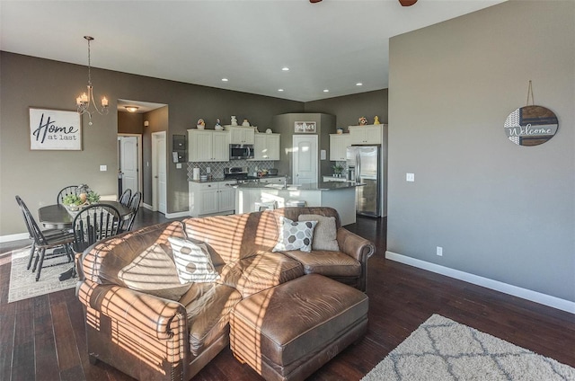 living room featuring dark wood-type flooring, sink, and a notable chandelier