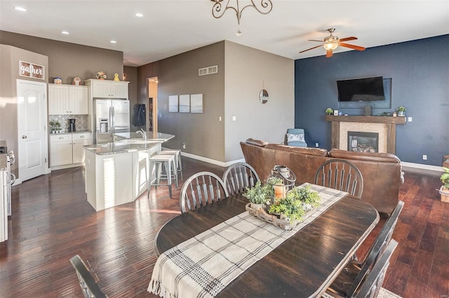 dining area with dark hardwood / wood-style floors, sink, and ceiling fan