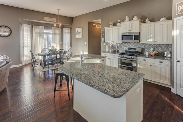 kitchen featuring pendant lighting, sink, white cabinets, a kitchen island with sink, and stainless steel appliances