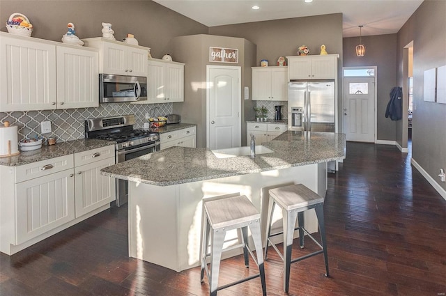 kitchen with sink, white cabinetry, a center island with sink, appliances with stainless steel finishes, and pendant lighting