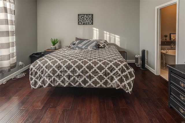 bedroom with dark hardwood / wood-style flooring and ensuite bath