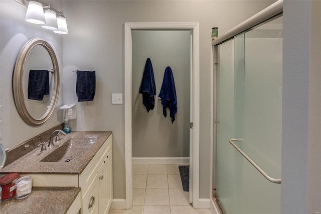 bathroom featuring vanity, a shower with shower door, and tile patterned floors