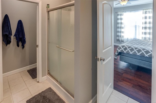 bathroom featuring tile patterned flooring, ceiling fan, and a shower with shower door