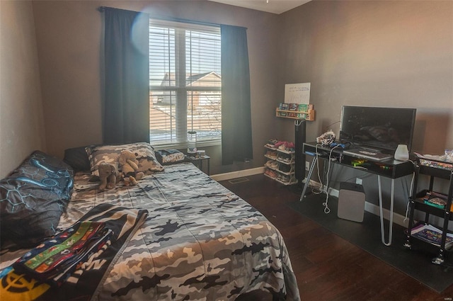 bedroom featuring multiple windows and dark wood-type flooring