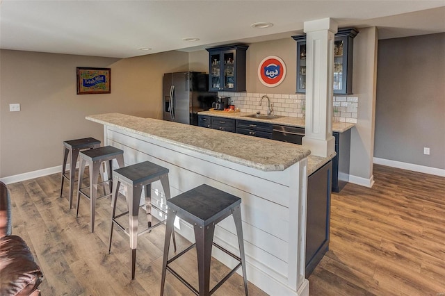 kitchen with sink, dishwasher, a center island, stainless steel refrigerator with ice dispenser, and tasteful backsplash