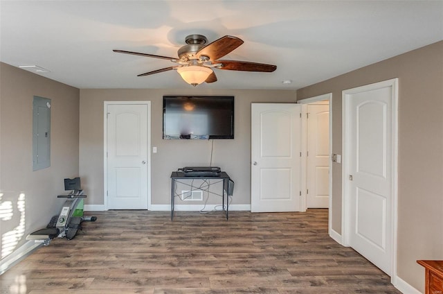 living room featuring ceiling fan, electric panel, and hardwood / wood-style floors