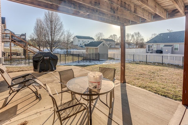 deck featuring grilling area, a storage unit, and a patio