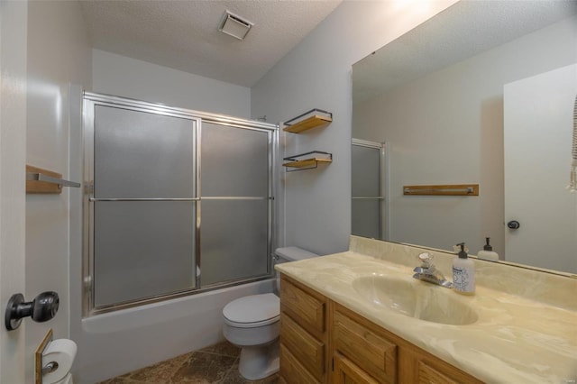 full bathroom featuring vanity, toilet, combined bath / shower with glass door, and a textured ceiling