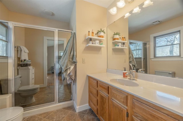 bathroom with vanity, toilet, a shower with shower door, and tile patterned flooring