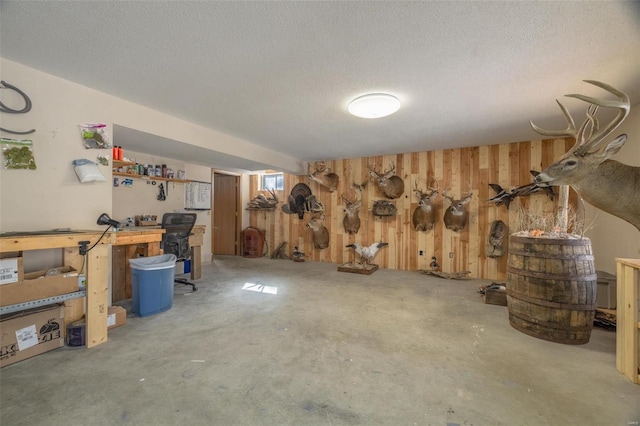 basement with a textured ceiling and wood walls