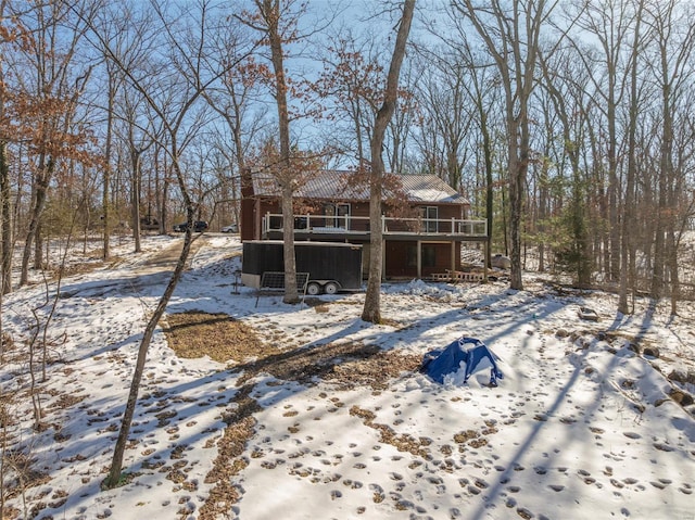 snow covered rear of property with a deck