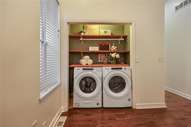 clothes washing area featuring dark hardwood / wood-style flooring and washer and clothes dryer