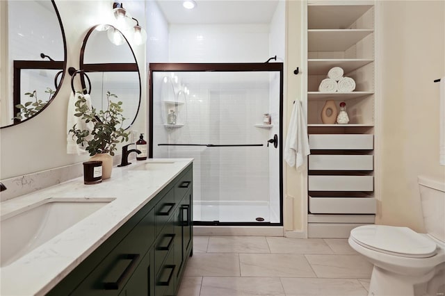 bathroom with vanity, toilet, and a shower with shower door