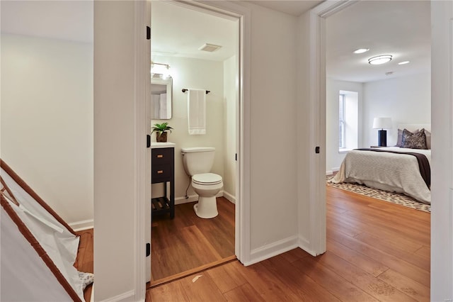 bathroom with hardwood / wood-style flooring, vanity, and toilet