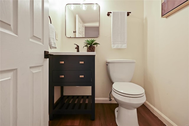 bathroom featuring wood-type flooring, toilet, and vanity