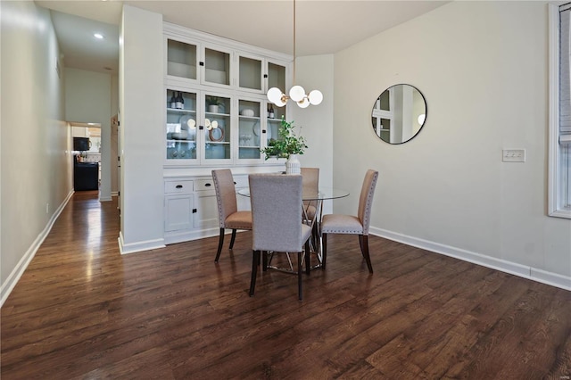 dining space with a notable chandelier and dark hardwood / wood-style flooring