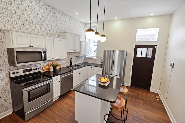 kitchen featuring sink, a kitchen island, white cabinets, and appliances with stainless steel finishes