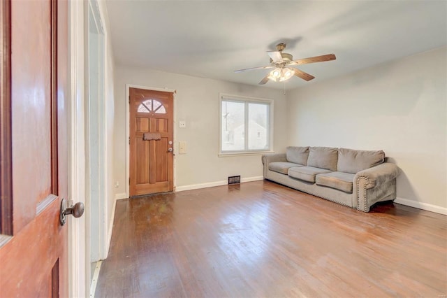 living room with a ceiling fan, dark wood-style flooring, and baseboards