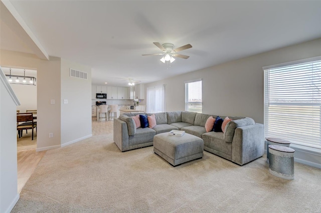 living room featuring light carpet and ceiling fan