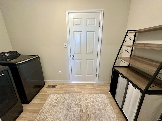 laundry room featuring washer / clothes dryer and light wood-type flooring