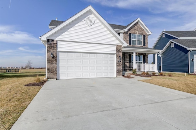 view of front of house with a garage, a front yard, and covered porch