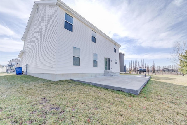 back of property with a lawn and a patio area