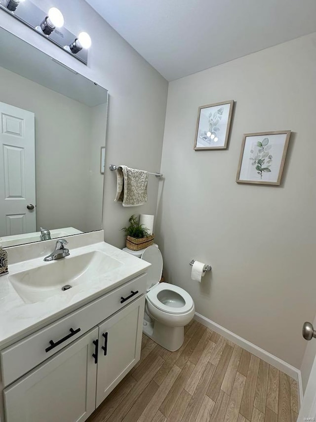 bathroom with vanity, hardwood / wood-style floors, and toilet