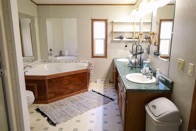 full bathroom featuring double vanity, toilet, tile patterned floors, a sink, and a bath