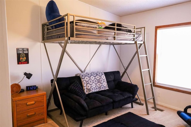 bedroom featuring visible vents, light carpet, and baseboards