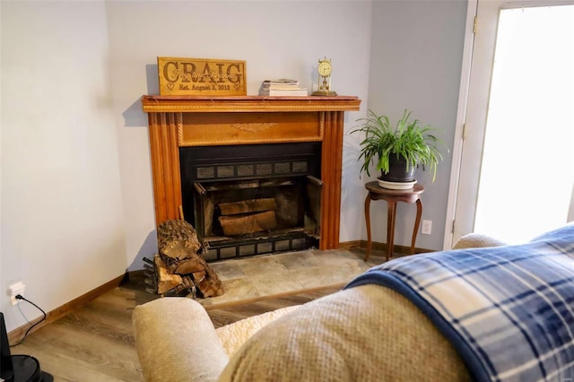 sitting room featuring a fireplace, wood finished floors, and baseboards