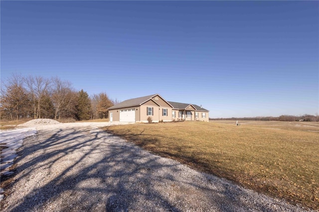 view of front facade featuring a garage, a rural view, and a front lawn