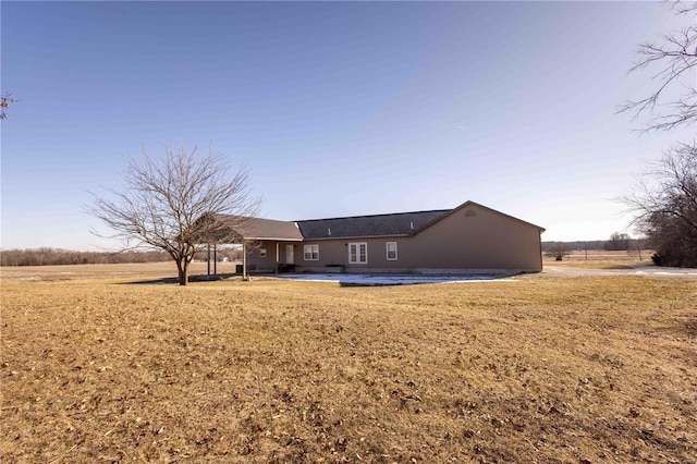 rear view of property featuring a rural view, a yard, and a patio