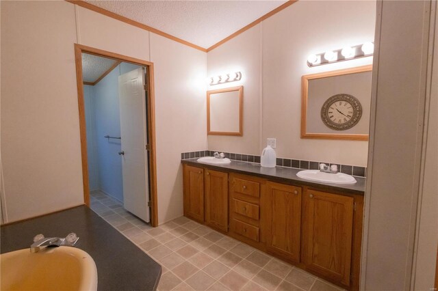 bathroom with crown molding, a bath, vanity, and a textured ceiling