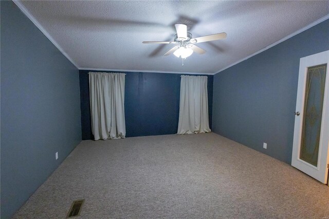 carpeted empty room featuring crown molding, ceiling fan, and a textured ceiling