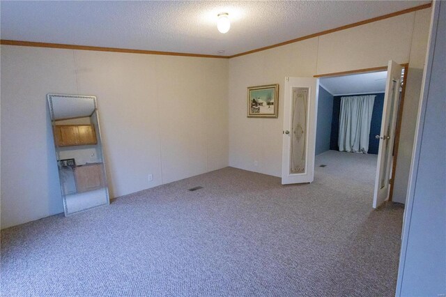 empty room with ornamental molding, a textured ceiling, and carpet flooring