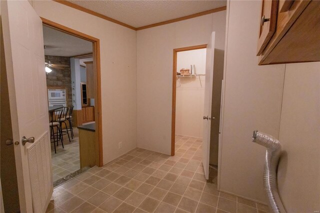 hallway featuring ornamental molding and a textured ceiling