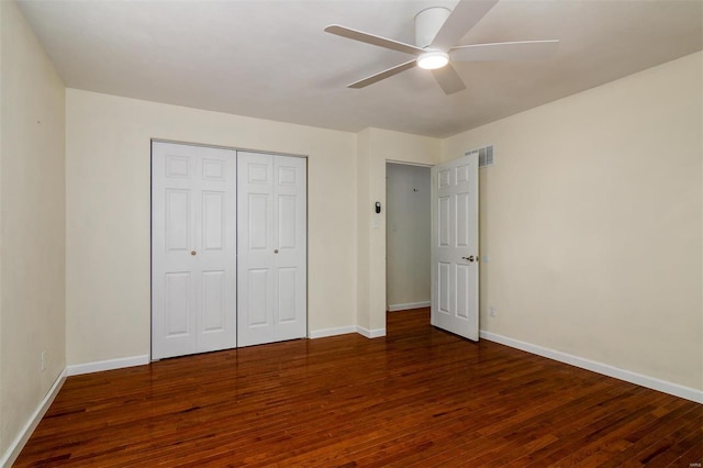 unfurnished bedroom with dark hardwood / wood-style flooring, ceiling fan, and a closet