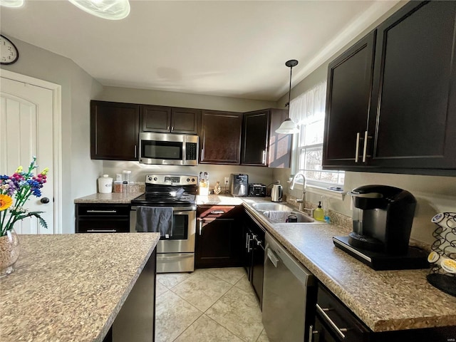 kitchen featuring appliances with stainless steel finishes, sink, hanging light fixtures, light tile patterned floors, and dark brown cabinetry