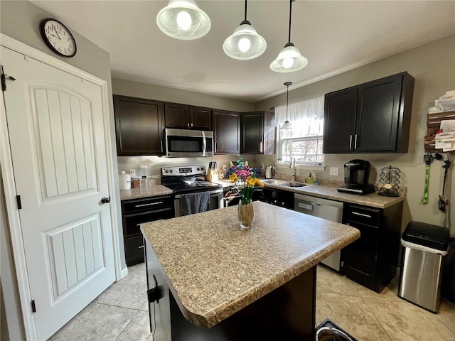 kitchen with sink, appliances with stainless steel finishes, a center island, dark brown cabinetry, and decorative light fixtures