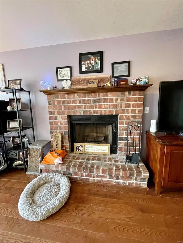 living room featuring hardwood / wood-style flooring and a brick fireplace