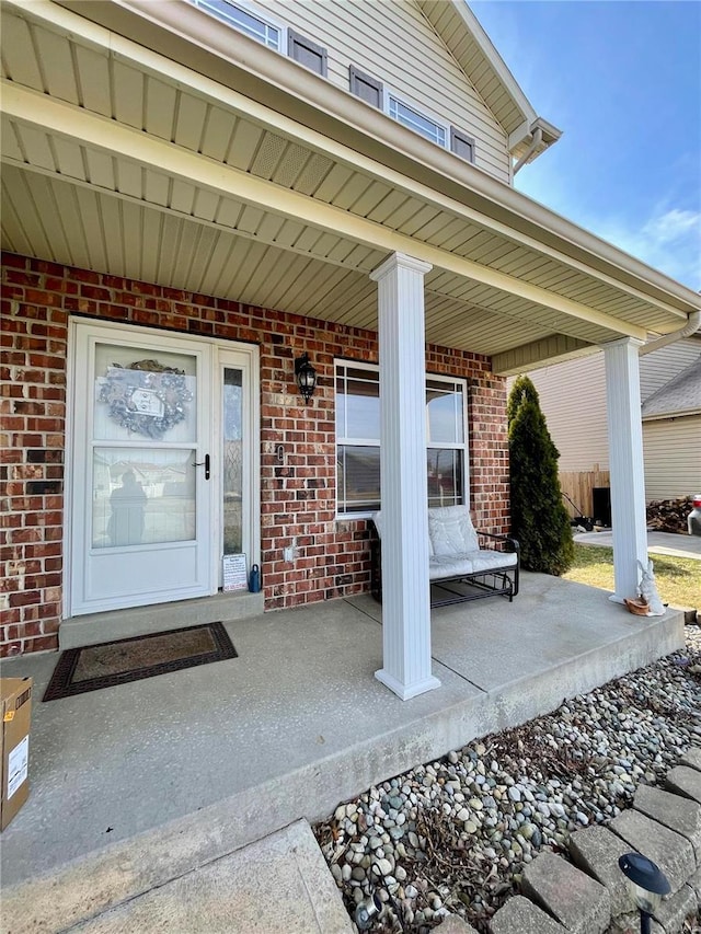 view of exterior entry featuring covered porch